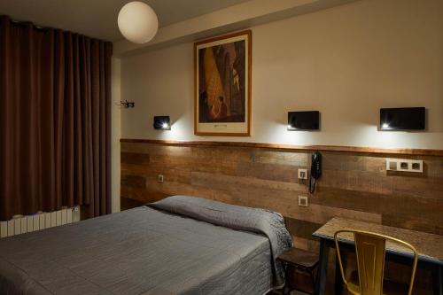 a bedroom with a bed and a table with chairs at Hôtel de Roubaix in Paris