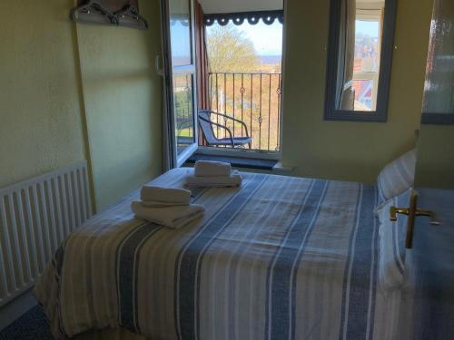 a bedroom with a bed with two towels on it at The Laurels Hotel in Skegness