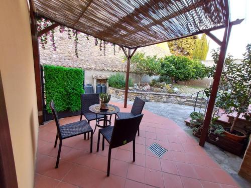 a patio with a table and chairs and a pergola at B&B Villa Martina in Sardara