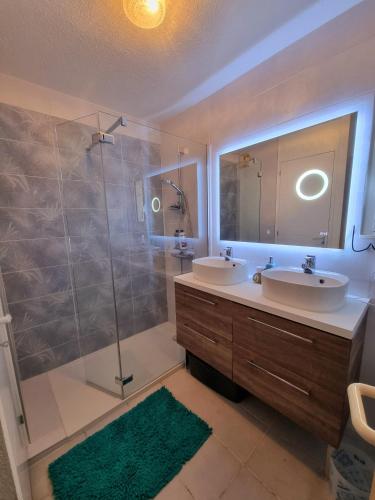 La salle de bains est pourvue de 2 lavabos et d'une douche avec un miroir. dans l'établissement Cap Capistol Golf, appartement 2 chambres, au Cap d'Agde