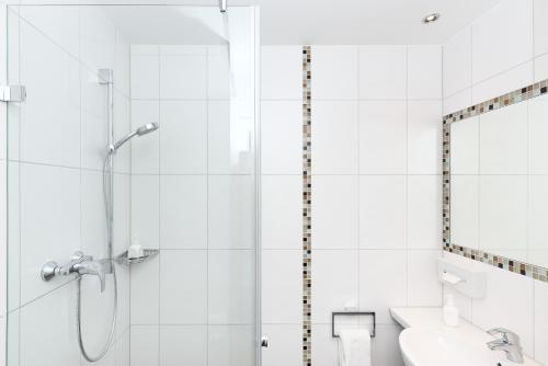 a bathroom with a shower, toilet and sink at Hotel Weisses Ross in Memmingen