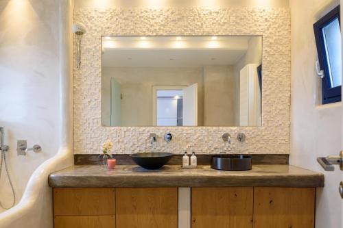 a bathroom with a sink and a mirror at Amor Hideaway Villas in Fira