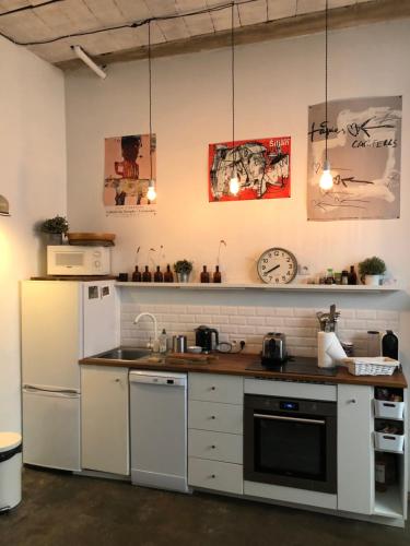 a kitchen with a white refrigerator and a sink at Le loft de cucuron in Cucuron