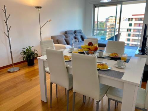uma sala de jantar com uma mesa branca e cadeiras em Concordia Apartment no Funchal