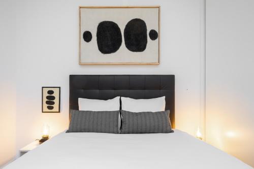 ein Schlafzimmer mit einem weißen Bett mit einem schwarzen Kopfteil in der Unterkunft WHome | Paz Downtown Apartment #2 in Lissabon