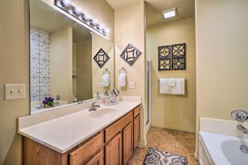 a bathroom with a sink and a mirror and a tub at Branson West Villa w/ Golf Course View & Pool! in Branson West