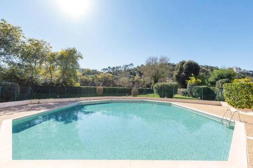une piscine avec de l'eau bleue dans une cour dans l'établissement Palme d'Or YourHostHelper, à Mandelieu-la-Napoule