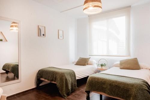 um quarto com 2 camas e um espelho em Apartamentos FV Flats Valencia - Mestalla 9 em Valência