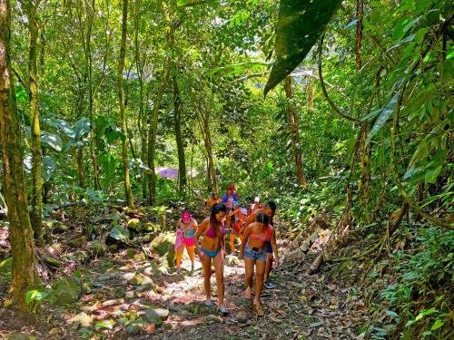 a group of people walking down a trail in the jungle at Termales el Escondite in Florencia