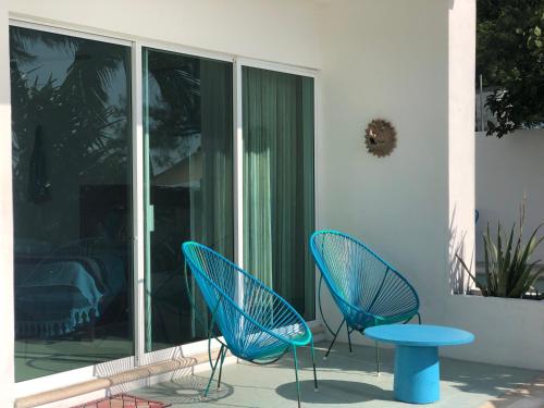 two blue chairs and a table on a patio at Playa 55 beach escape - adults only Guesthouse in Celestún