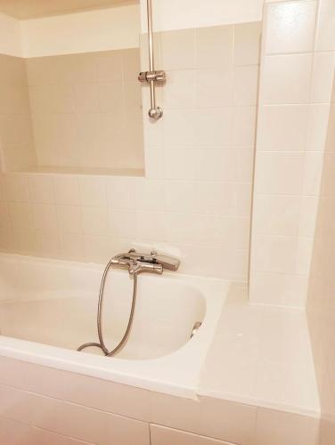 une baignoire blanche avec douche dans une salle de bain dans l'établissement Studio vieil Antibes, à Antibes