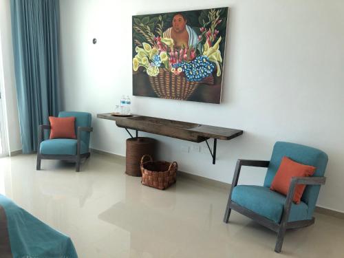 a room with two chairs and a painting on the wall at Playa 55 beach escape - adults only Guesthouse in Celestún