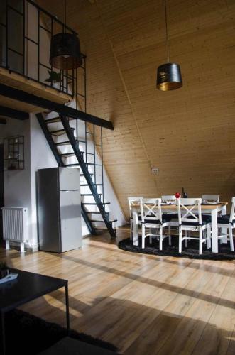 a room with a table and chairs and a staircase at Zenith A-Frame Straja in Lupeni