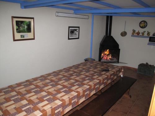 CASA RURAL HOCES DEL MESA في خارابا: غرفة نوم بها سرير وموقد