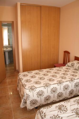 a bedroom with two beds and a wooden cabinet at CASA RURAL HOCES DEL MESA in Jaraba