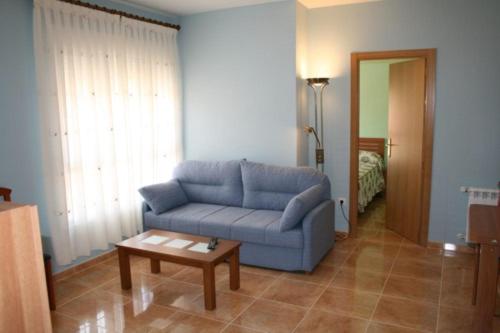 a living room with a blue couch and a coffee table at CASA RURAL HOCES DEL MESA in Jaraba