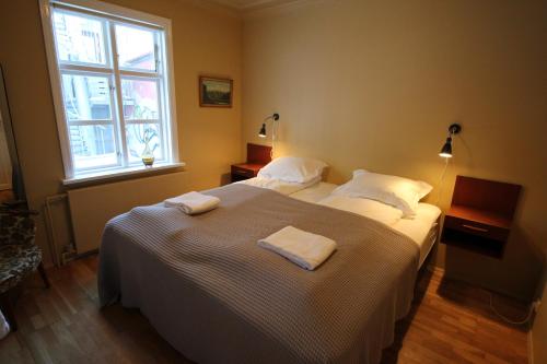 a bedroom with a bed with two towels on it at Grettir Guesthouse in Reykjavík