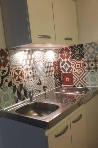 a kitchen with a sink and tiles on the wall at Studio à Rambouillet in Rambouillet