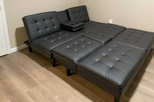 a black leather couch with a suitcase on it at Painted Skies Upscale Getaway By Lake Burton! in Tiger
