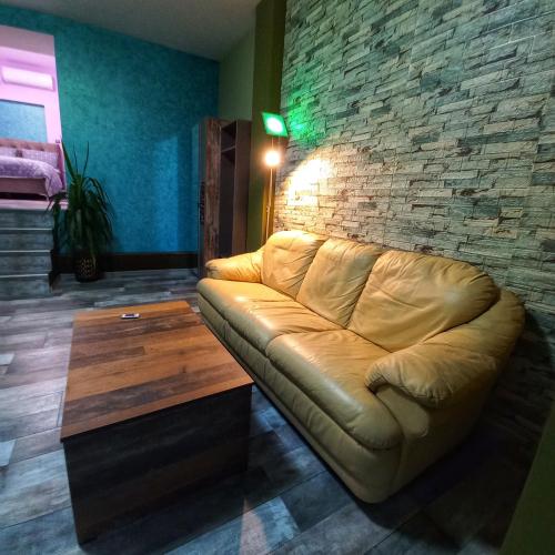 uma sala de estar com um sofá e uma parede de tijolos em Старата Лоза em Montana