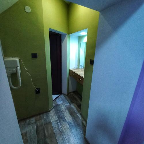 a bathroom with green and yellow walls and a sink at Старата Лоза in Montana