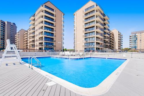 a swimming pool with two tall buildings in the background at Sea Colony - 19006 Lakeview Court in Bethany Beach