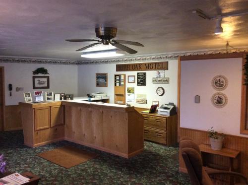 a large room with a desk and a ceiling fan at Burr Oak Motel in Algona