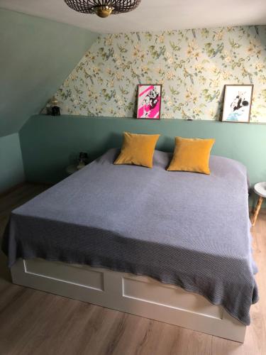 um quarto com uma cama com almofadas amarelas em Paradiesje 2 em Leer