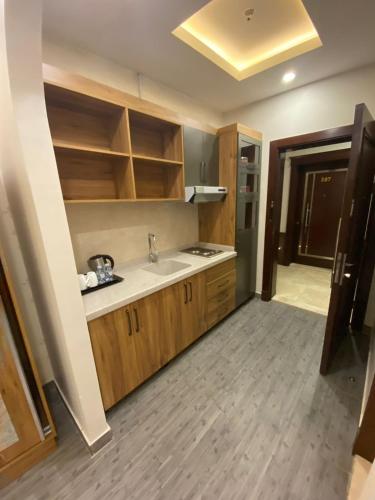 a kitchen with wooden cabinets and a sink at PRIMOTEL Elite As Salamah - Serviced Apartments in Jeddah