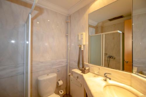 y baño con aseo, lavabo y espejo. en Hotel Kypreos, en Kamena Vourla