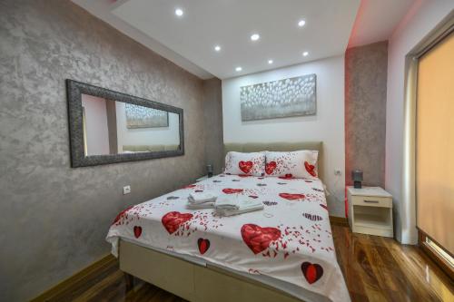 a bedroom with a bed with red hearts on it at Apartman 3M Lux in Vrnjačka Banja