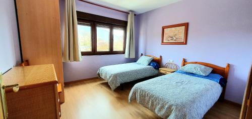 ein kleines Schlafzimmer mit 2 Betten und einem Fenster in der Unterkunft Piso El PUNTUAL de arriondas in Les Arriondes