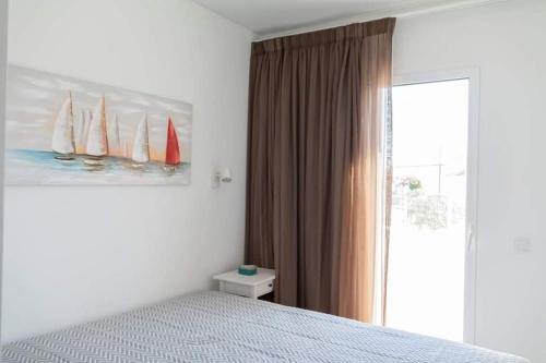 um quarto com uma cama e um quadro de veleiros em Casa dos Terraços Apartamentos em São Martinho do Porto