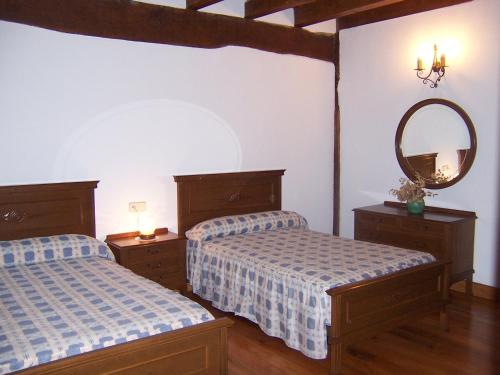 a bedroom with two beds and a mirror at Casa Rural Barbonea in Lekunberri