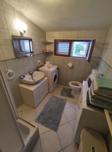 ein Bad mit einem Waschbecken und einem WC in der Unterkunft Apartman Arijana in Rogoznica