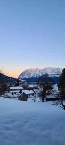 a field covered in snow with a mountain in the background at Ferienwohnungen Bergpanorama in Bad Mitterndorf