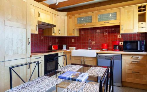 uma cozinha com armários de madeira e uma mesa em Appartement Le Caboen Les Planards em Chamonix-Mont-Blanc