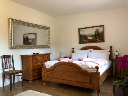 een slaapkamer met een bed, een spiegel en een stoel bij A&N Prestige Apartments "Attika" close to BASEL and Rhine river in Grenzach-Wyhlen