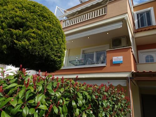 a house with a tree in front of it at Bella Casa in Nea Peramos