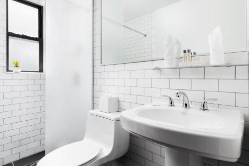 a white bathroom with a toilet and a sink at OYO Times Square in New York