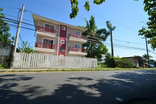 a red and white house with a white fence at Caribbean Villages Aparments in Bocas del Toro