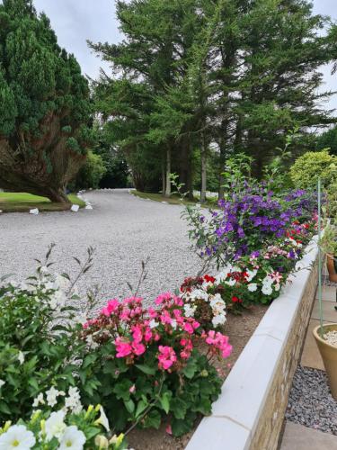 a garden with pink and purple flowers on a path at Balcary Bay Country House Hotel in Auchencairn