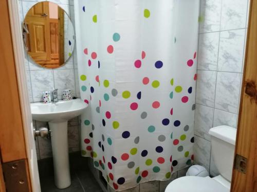 baño con cortina de ducha con lunares en Hotel Cochamó en Cochamó