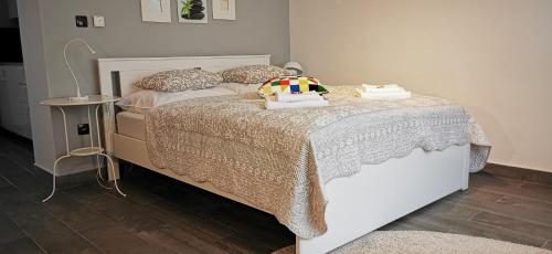 sypialnia z łóżkiem z białą narzutą i poduszkami w obiekcie Nora 1 w Zagrzebiu
