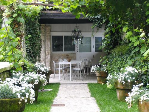 a patio with a table and chairs in a garden at Enoturismo Novavila Rias Baixas Wine Design in Meis