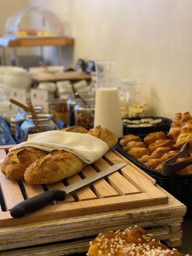 Una mesa con un montón de panes y otros pasteles. en Best Western Le Relais du Vigneron, en Vertus