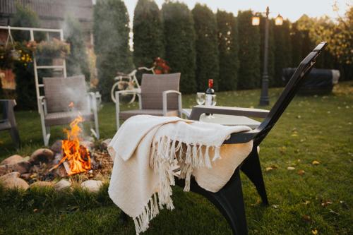 a blanket on a bench next to a fire at Guest House Lorem in Daugavpils