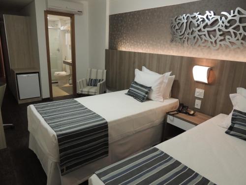 A bed or beds in a room at Allia Gran Pampulha Suites