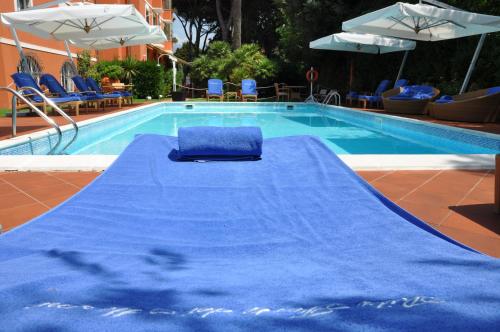 a swimming pool with a blue mat in front of it at Hotel 1908 in Forte dei Marmi