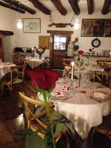 a dining room with tables with flowers and candles at Logis Hotel La Grange Du Relais in Colombey-les-deux-Églises